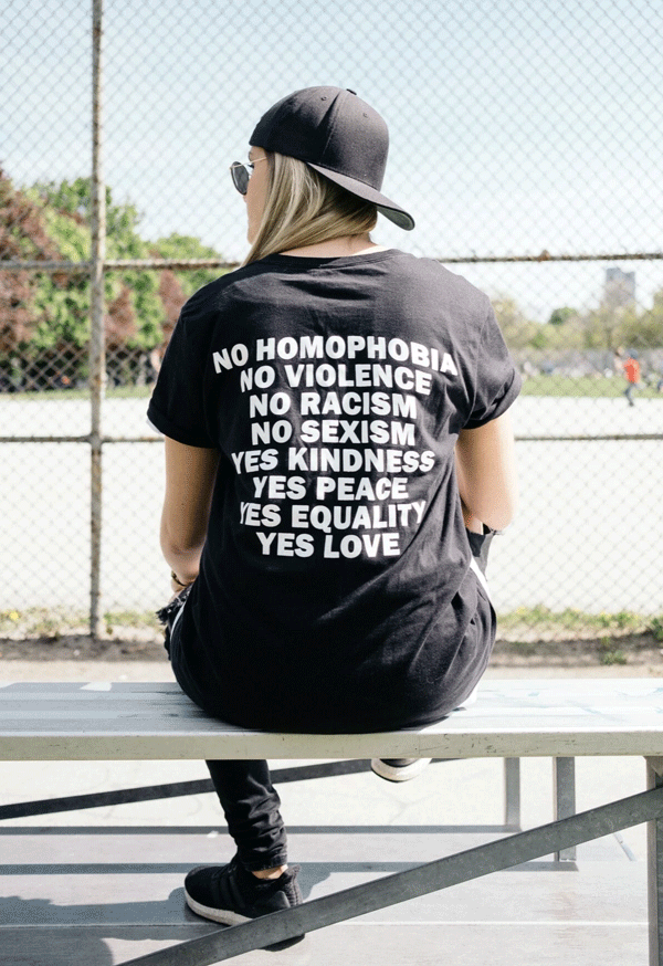 A t-shirt that has the message No Homophobia, No Violence, No Racism, No Sexism, Yes Kindness, Yes Peace, Yes Equality, Yes Love on the back