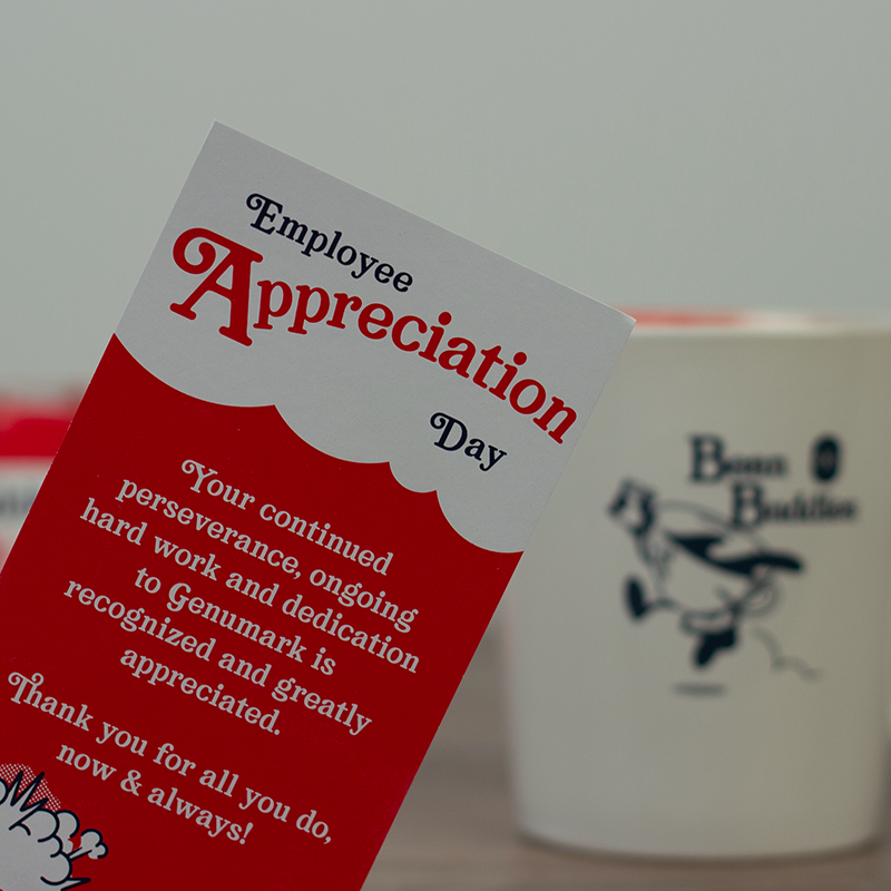 Genumark Employee Appreciation bookmark closeup with branded mug background